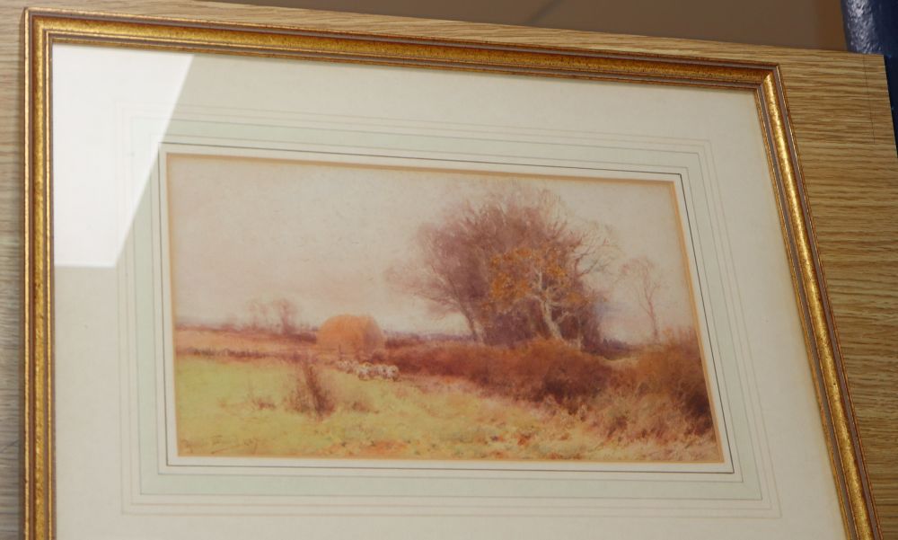 Henry John Sylvester Stannard (1870-1951), landscape with sheep and a hayrick in the distance, 15.5cm x 28.5cm